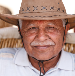 man with white hair wearing wide brimmed hat