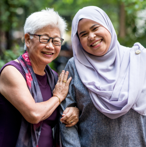 Older woman smiling and holding the arm of a younger woman